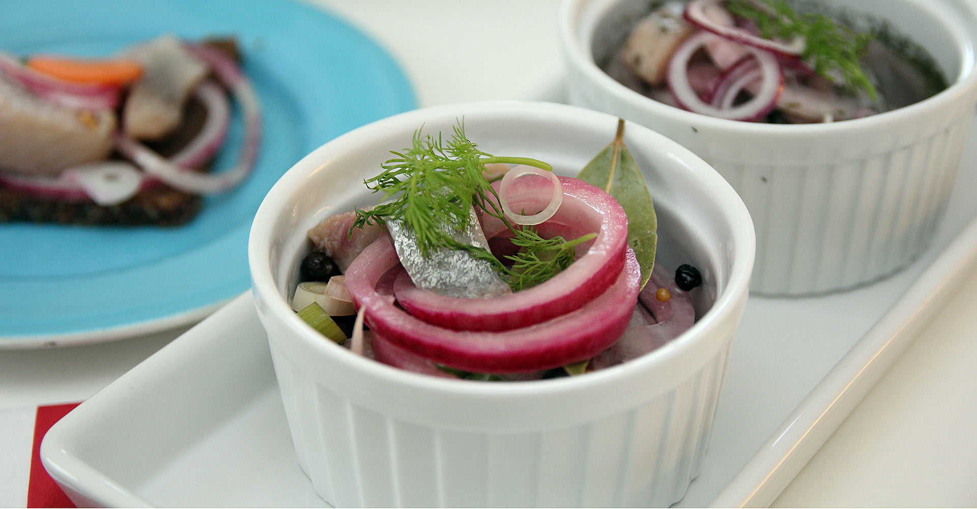 Picture of pickled herring pickled in a glass jar.
