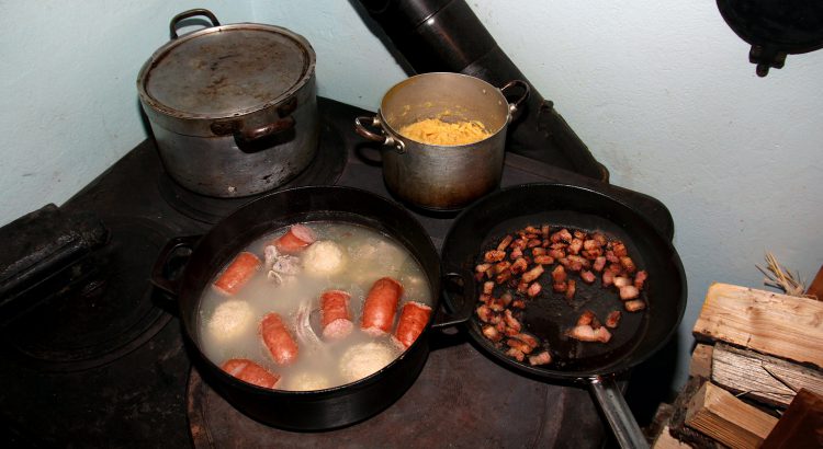 Cooking salted meat, raspeball, sausage, sweed mash on an old wooden stove.