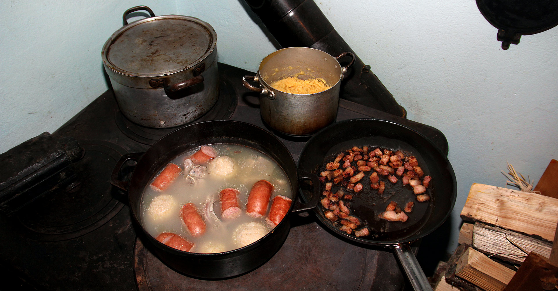 Cooking salted meat, raspeball, sausage, sweed mash on an old wooden stove.